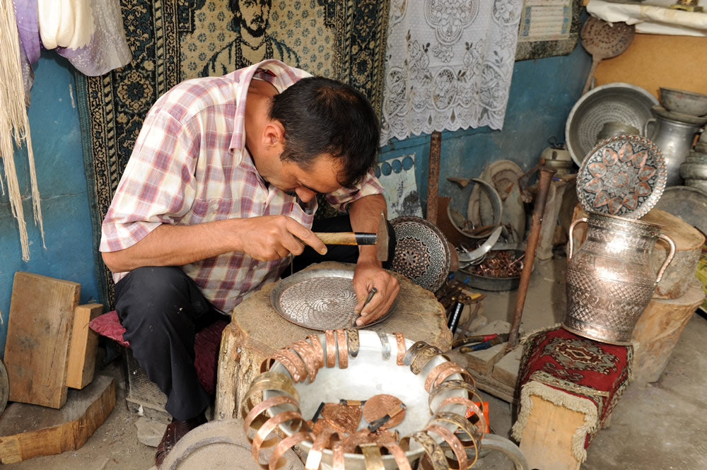 craftsman working on copper plate